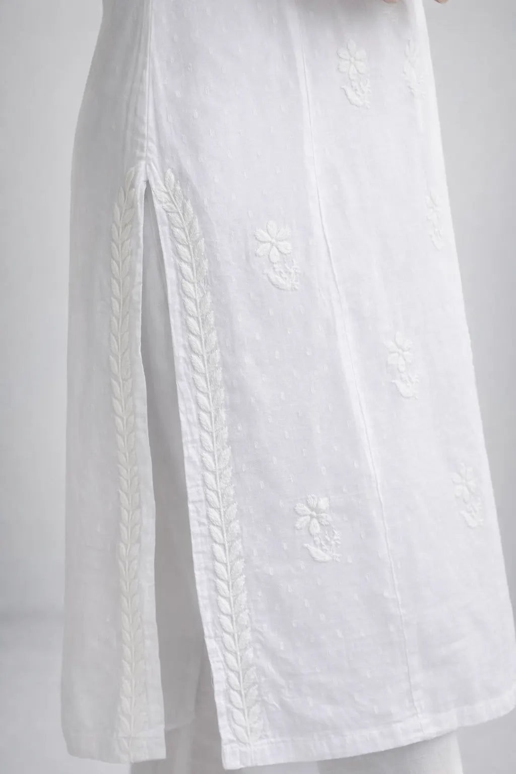 Side slit detail of white cotton Chikankari kurti with hand embroidery
