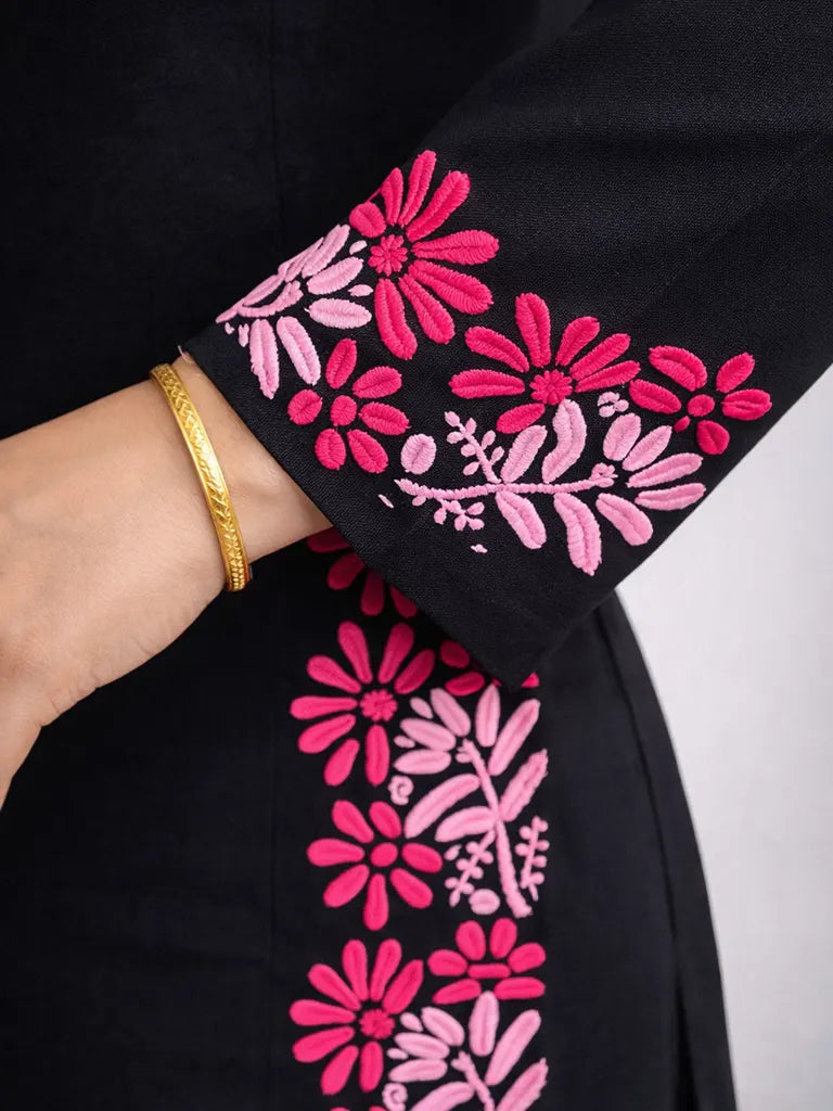 Macro view of pink floral Chikankari hand embroidery on black cotton kurti sleeve