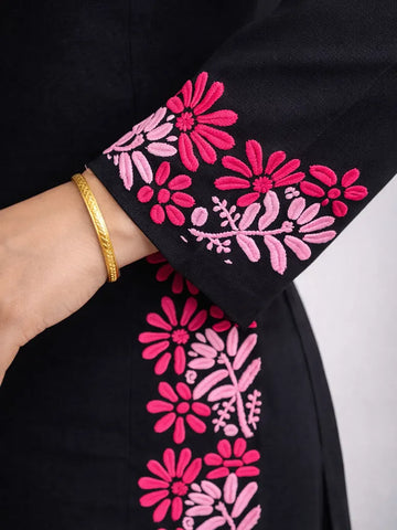 Macro view of pink floral Chikankari hand embroidery on black cotton kurti sleeve
