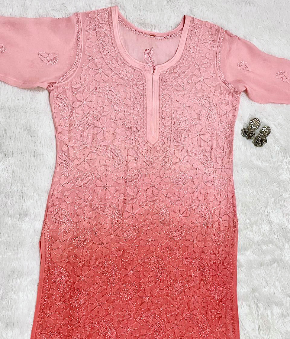 Pink embroidered dress on a textured white background front photo