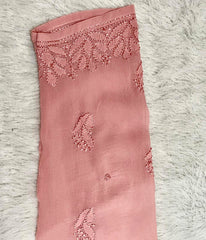 Pink fabric with lace detailing on a textured white surface sleeve design
