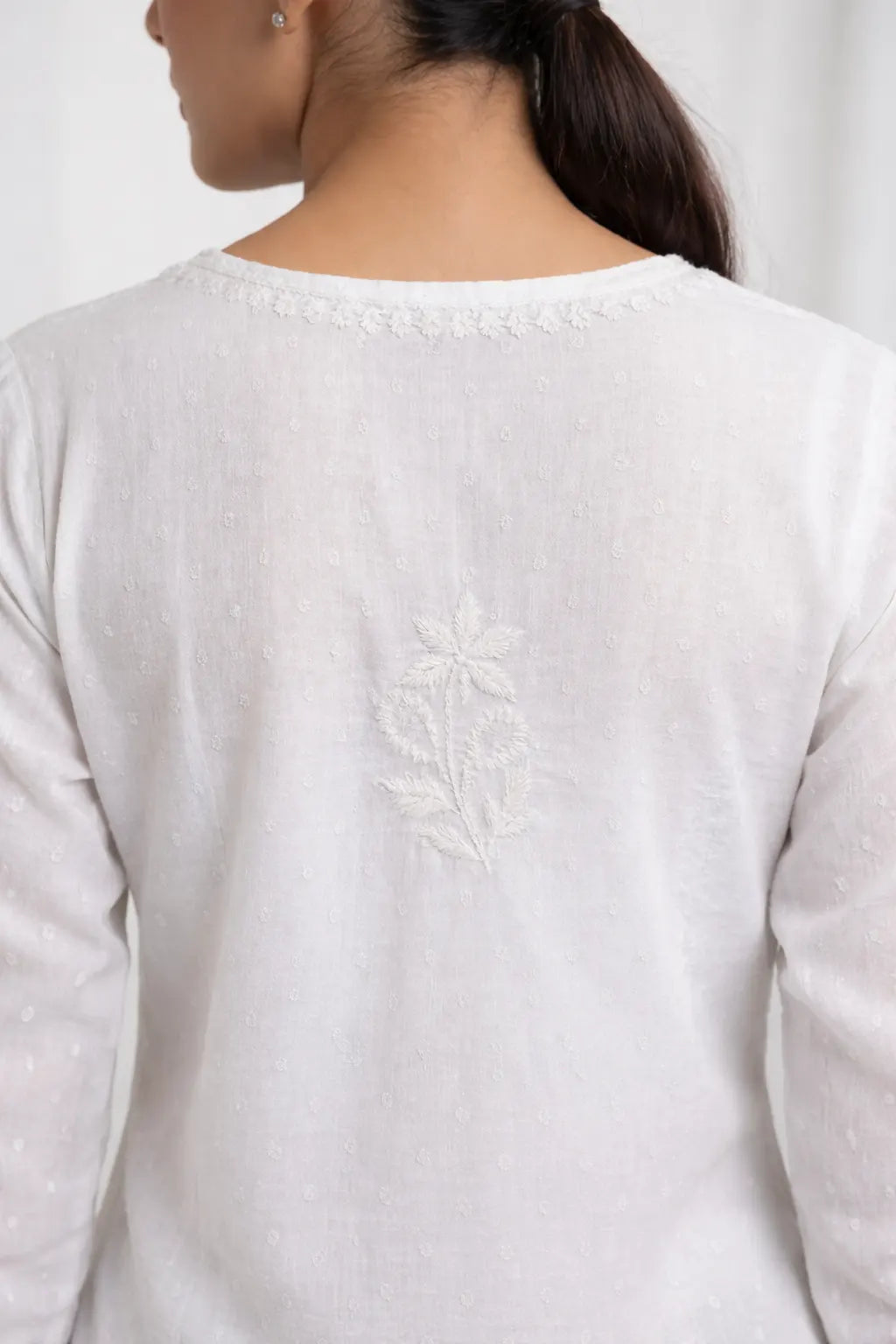 Back view of white Chikankari kurti featuring delicate hand embroidered floral motif. Back Hand Embroidery on White Chikankari Kurti